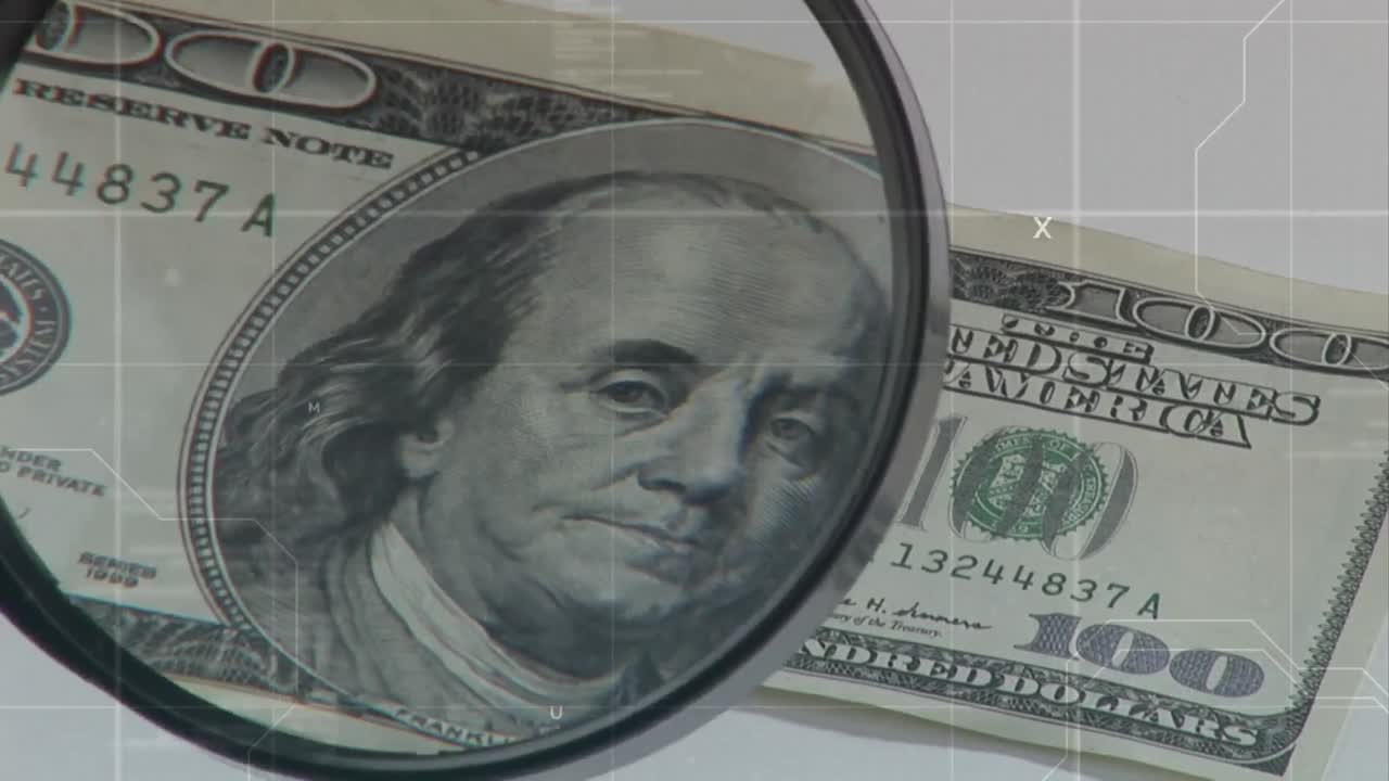 lente di ingrandimento su una banconota da cento dollari