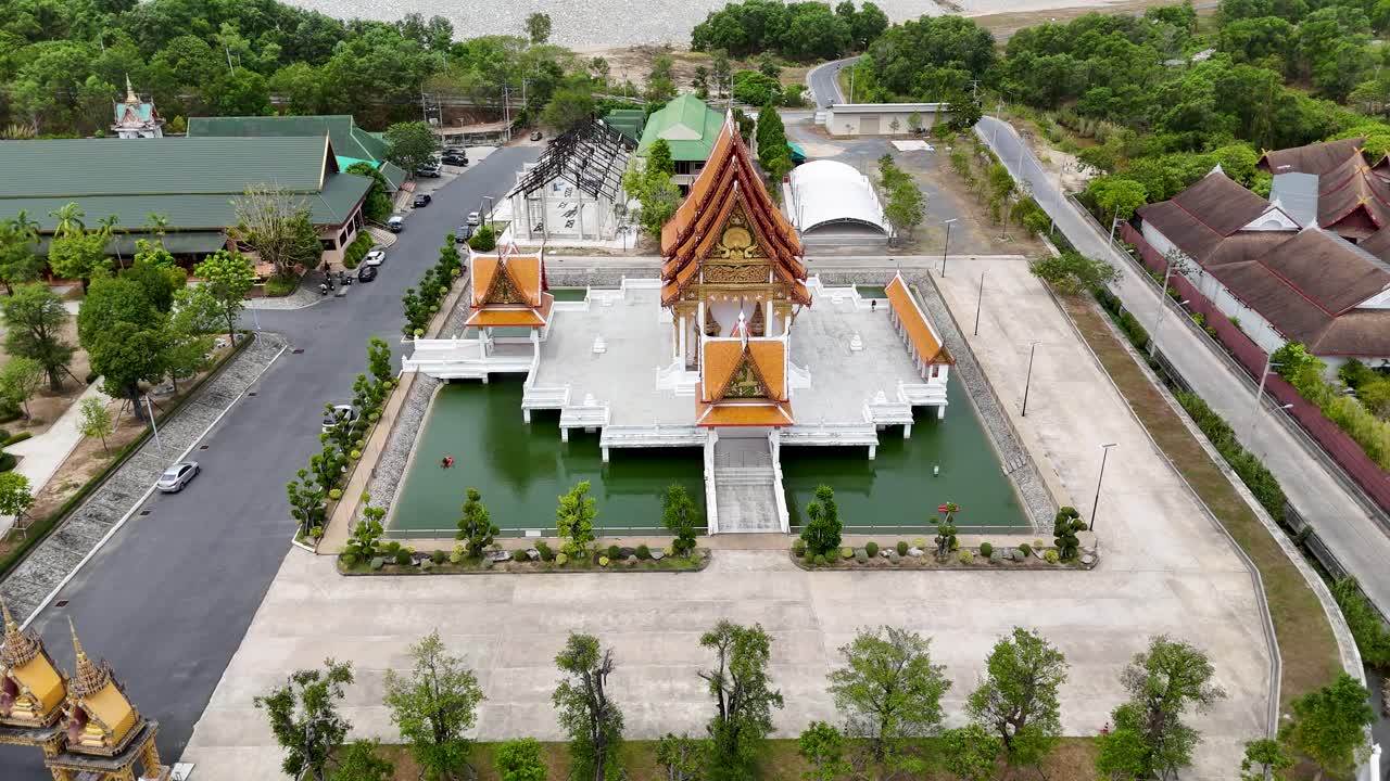 las imágenes de drones capturan un sereno templo budista en phuket, tailandia, que muestra la arquitectura tradicional y los alrededores exuberantes a la luz del día.