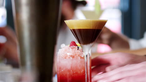 close up of barman serving espresso martini cocktail in bar