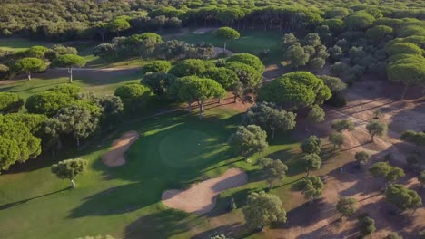 Toma-Aérea-Ascendente-De-Un-Hoyo-Rodeado-De-Bunkers-De-Arena-En-Un-Campo-De-Golf-Mediterráneo