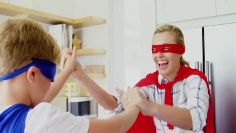 madre e hijo disfrazados de superhéroes dándose un high five 4k