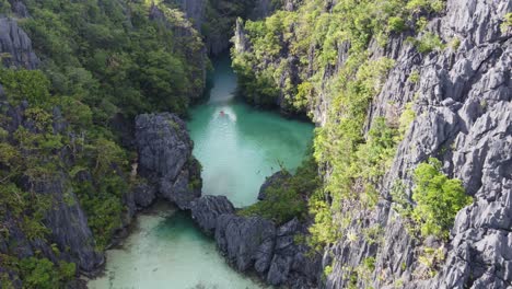 one kayaker solo kayaking small lagoon in el nido, aerial