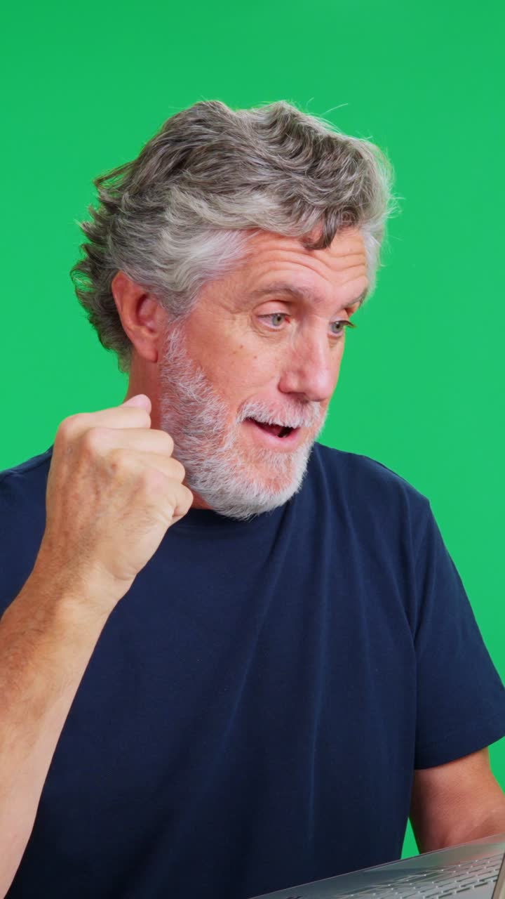 Mature Man Working on Laptop Has Sudden Realization and Celebrates