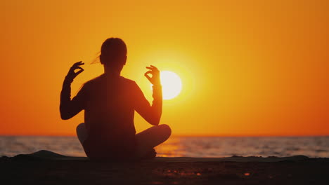 mujer joven medita en un lugar pintoresco al atardecer