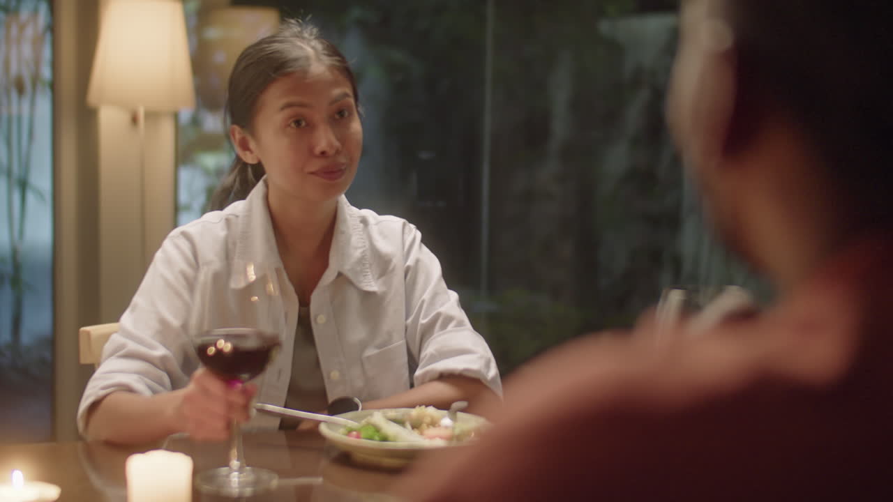 Asian Woman Talking with Husband over Dinner at Home