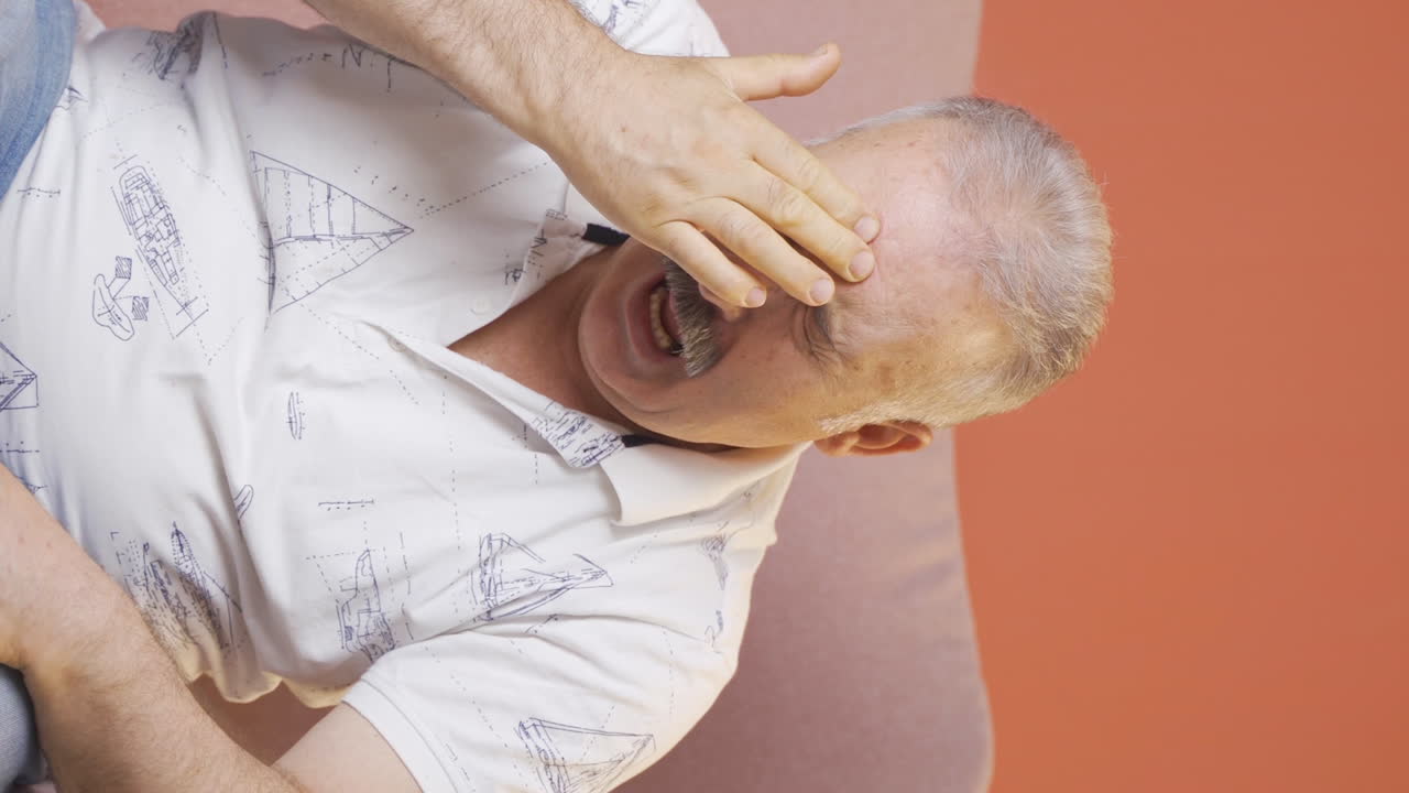 vídeo vertical de un anciano con migraña está experimentando dolor.