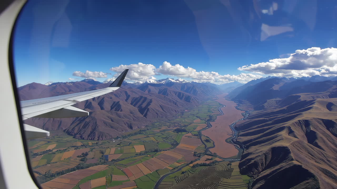 Aerial View of Mountains and River from Airplane Window