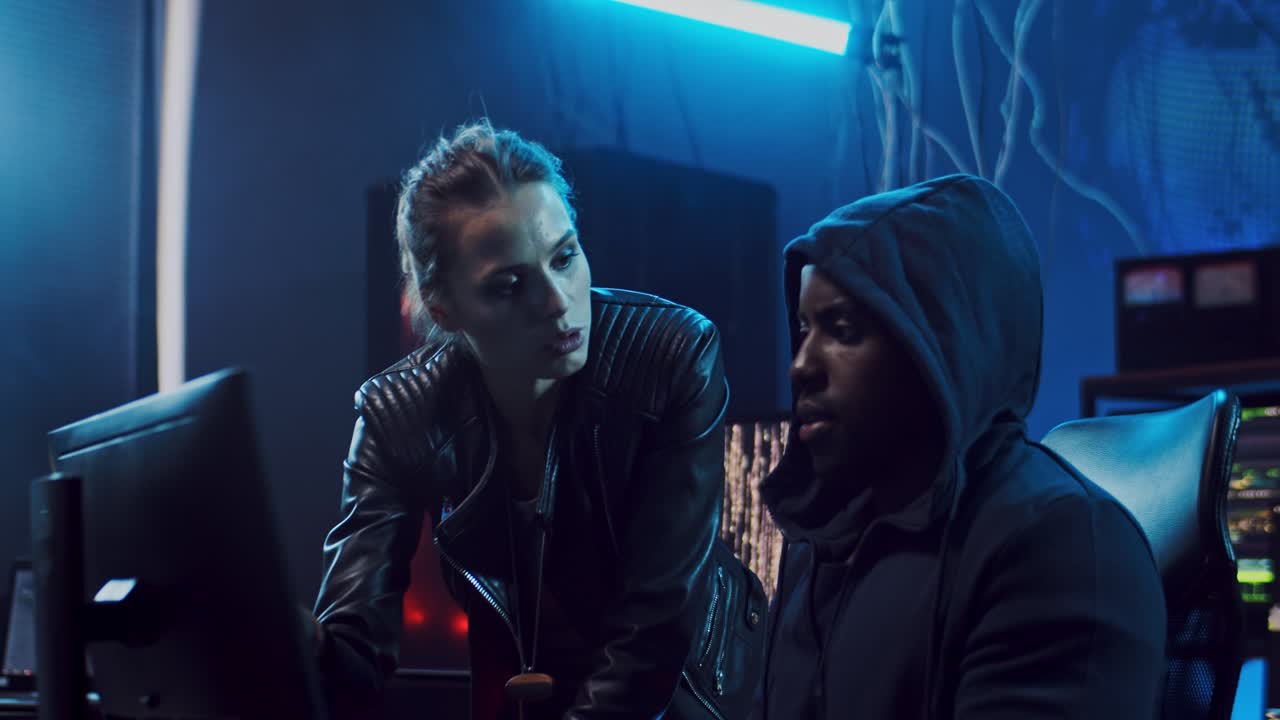 красивые женщина и мужчина, работающие вместе ночью, хакеры или разработчики программного обеспечения, разговаривающие перед экраном компьютера