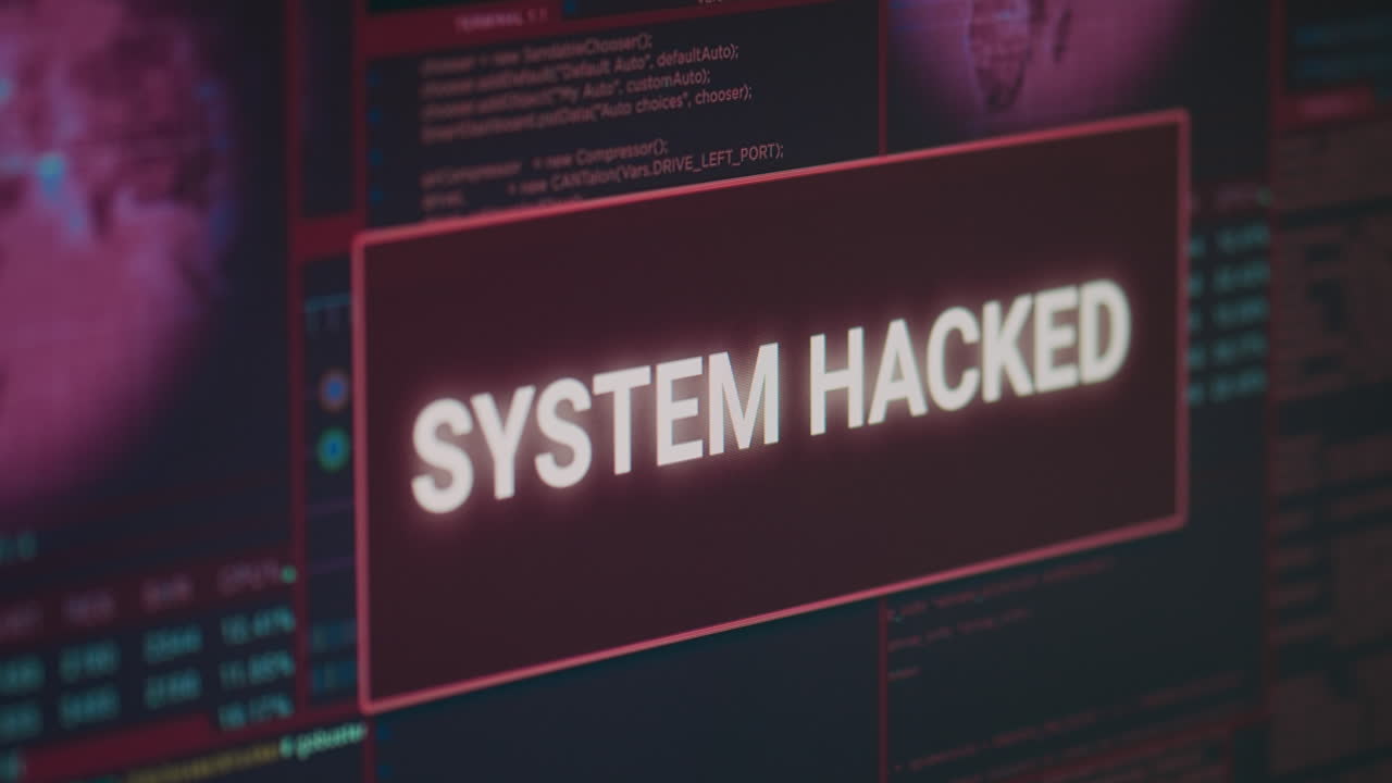 Computer monitor showing hacked system alert message flashing on screen