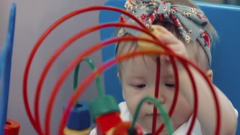 niño juega con un juguete multicolor 19 mamá ayuda