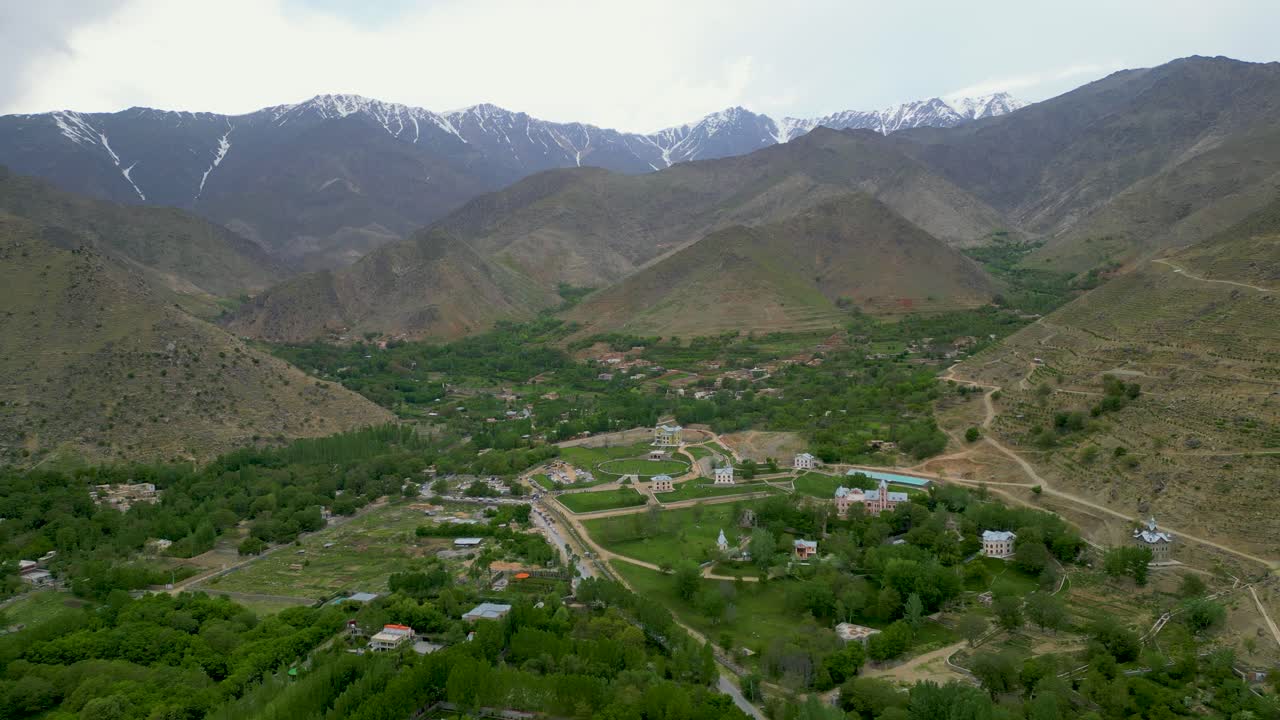 Aerial drone view of a river winding through a lush, rugged mountain valley in Kabul, Afghanistan