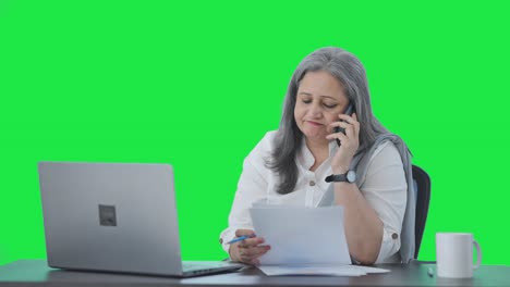 Indian-senior-female-manager-talking-on-phone-Green-screen