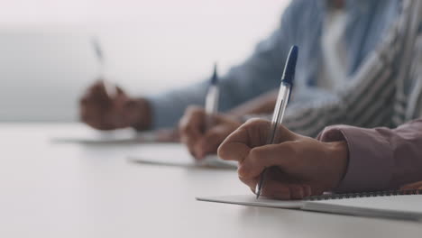 people taking notes in a meeting or class