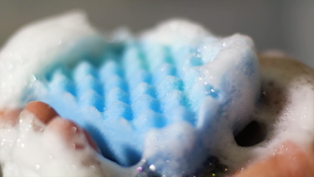 클로즈업 샷은 주방 용품을 씻은 후 스펀지를 짜낸다