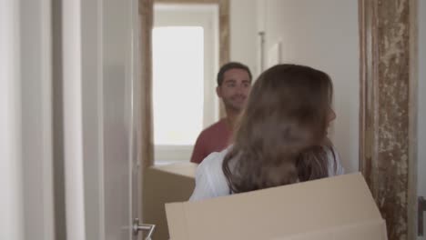 happy caucasian couple coming into new house or apartment for the first time