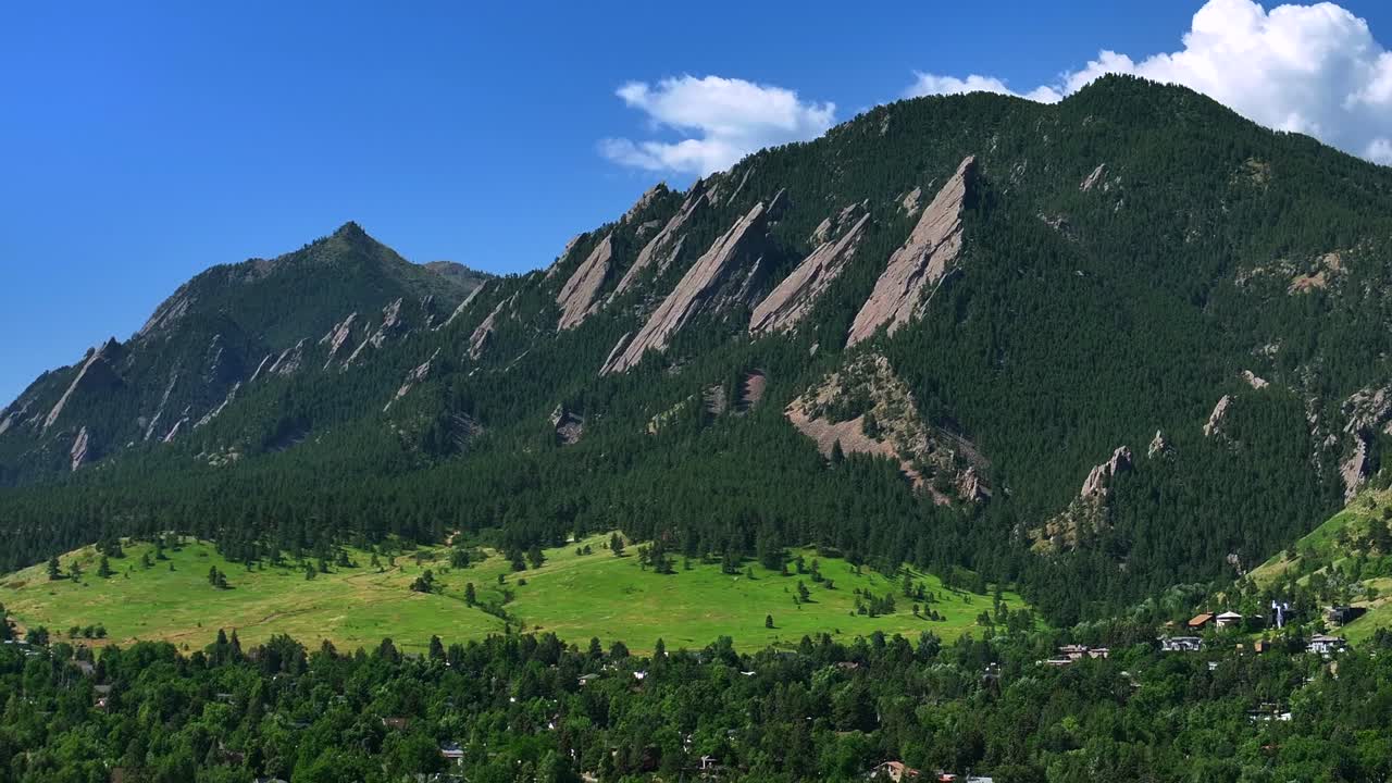 University city town of Boulder Colorado Pearl Street Mall Flatirons slanted Rocky Mountains aerial drone upwards Chautauqua Park Boulder Creek Canyon Mountain Park hiking trails summer clear blue sky