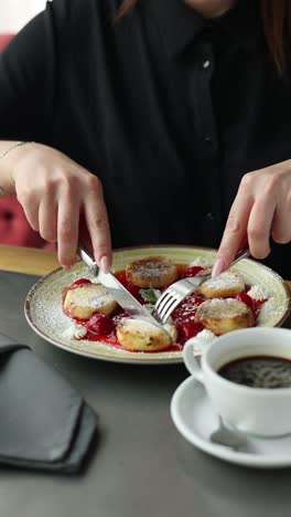 woman eating syrniki with coffee