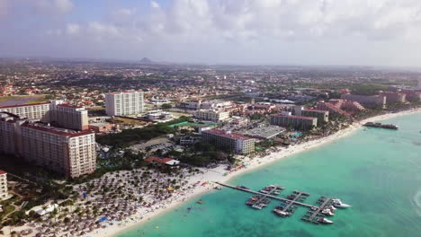 Toma-Aérea-De-Palm-Beach,-Aruba-Y-Barcos-En-El-Mar-Caribe