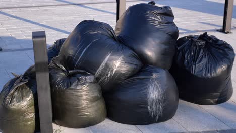 pile of black garbage bags on the street