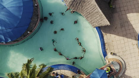 people having fun and playing games in the water pool in water park in summer