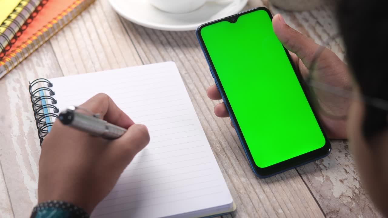 top view of man hand using smart phone on office desk