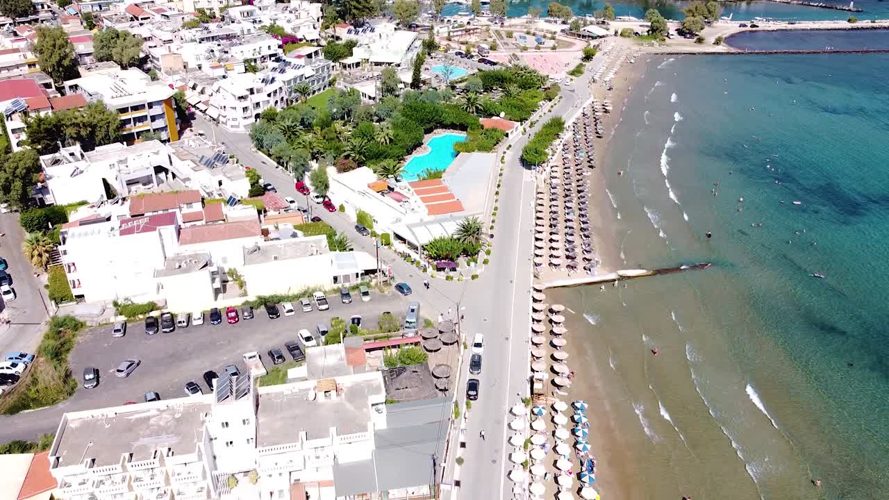 Sandy coast and beautiful resort township in Crete, aerial view