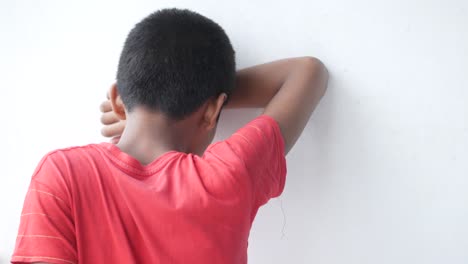 niño triste escondiendo su rostro