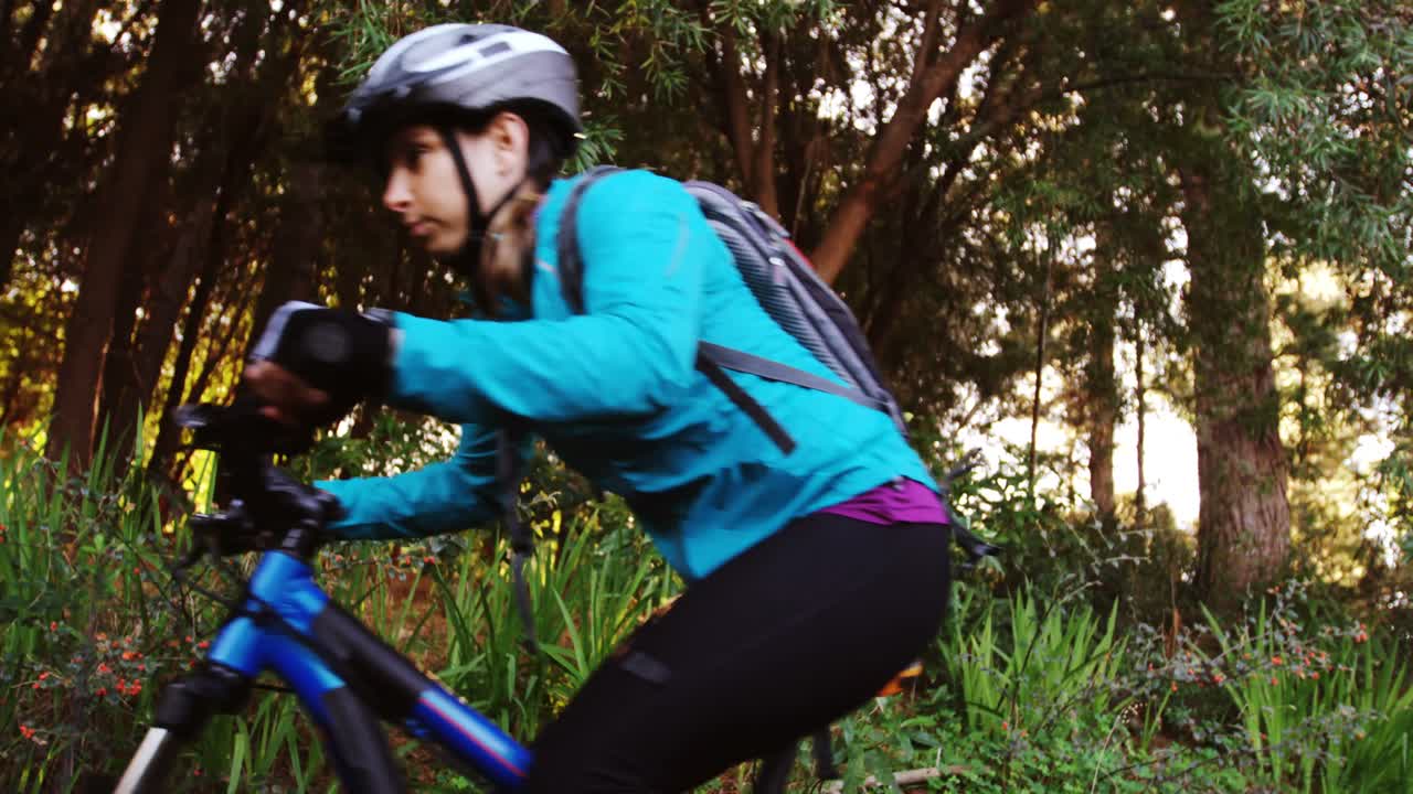 bicicleta de montaña femenina cabalgando en el bosque