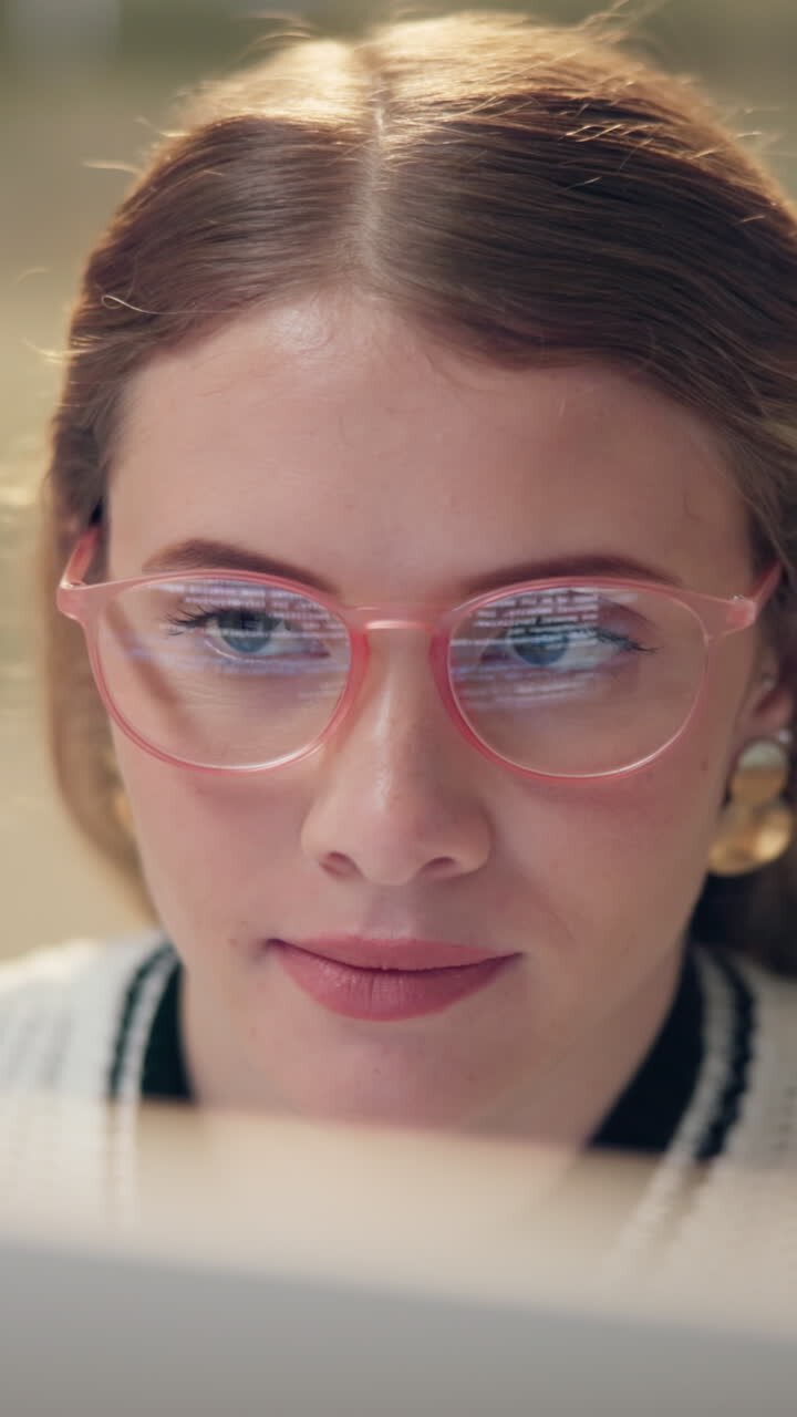 Donna con gli occhiali che guarda uno schermo di computer