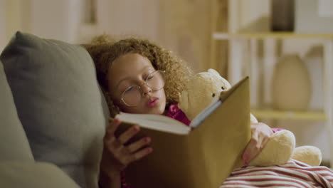 linda chica leyendo historias interesantes antes de quedarse dormida