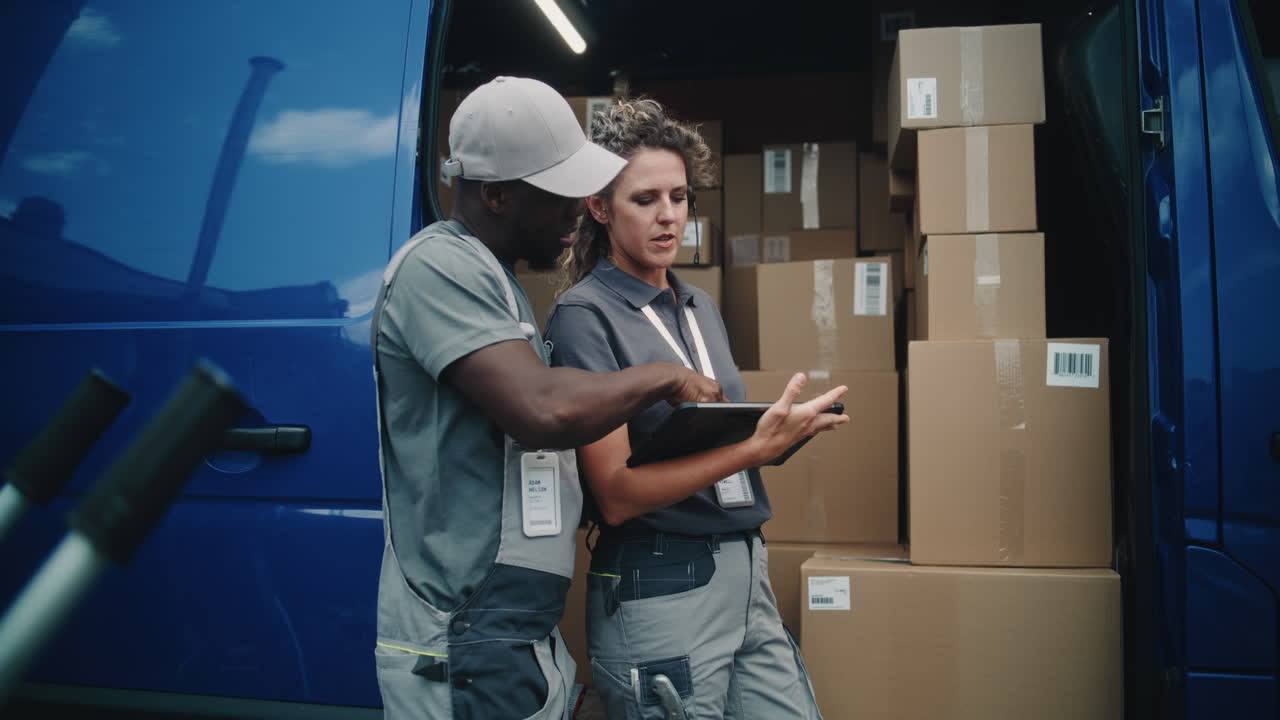 Two Delivery Workers Checking Packages in a Van
