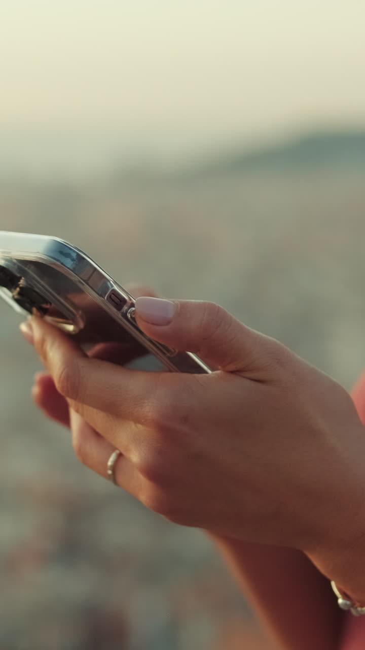 Person using a smartphone with a cityscape in the background