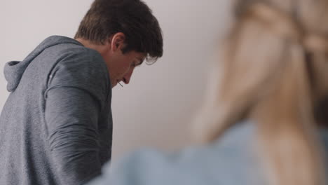 pareja feliz mudándose a una nueva casa colgando fotos en la pared decorando la casa disfrutando del trabajo en equipo 4k