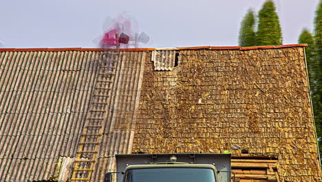 time lapse shot of man on ladder uncover roof tiles of house roof during sunset time