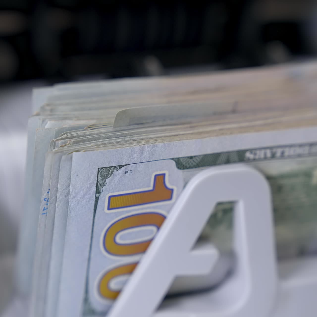 Paper cash money calculation. Electronic money counter machine is counting paper banknotes. Detailed view currency of hundred bills on counter machine