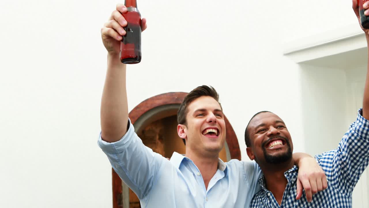 amigos masculinos viendo un partido de fútbol mientras beben cerveza 4k