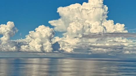 un impresionante lapso de tiempo de enormes nubes blancas y esponjosas bailando alrededor de un océano tranquilo y reflectante