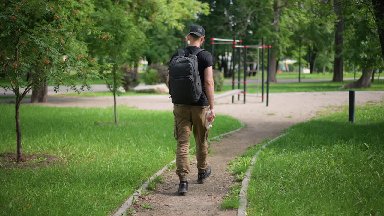 Lonely Man Strolls, Peaceful Solitary Person Meanders Softly Across Flourishing Park Scenery, Serene Individual Walks Quietly Alone Amidst Abundant Lush Foliage And Blooming Plants