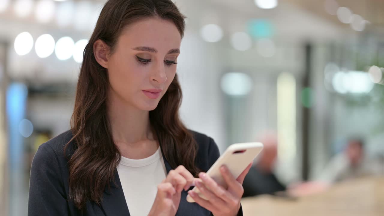 Donna d'affari che celebra il successo sullo smartphone, business online