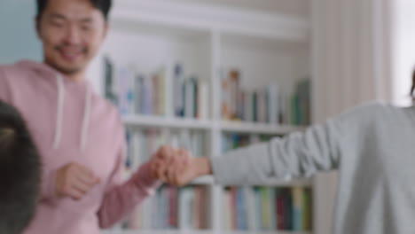 familia asiática feliz bailando en casa divirtiéndose bailando celebrando juntos niños pequeños celebrando con mamá y papá disfrutando de un emocionante fin de semana 4k