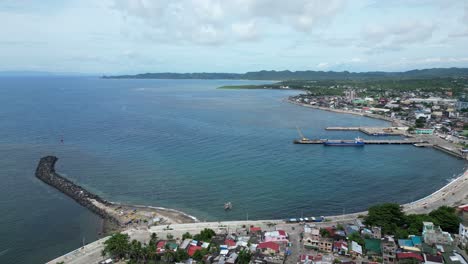 aerial, rising, drone view of peaceful waterfront town and port in virac, catanduanes, philippines