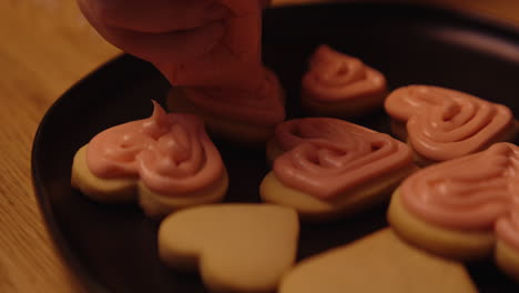 decorating heart-shaped cookies with pink icing