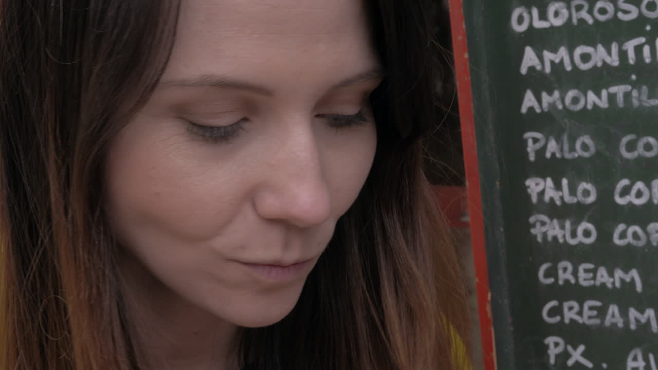 mujer bebiendo vino con queso en un café al aire libre