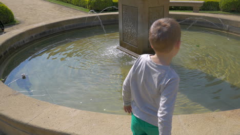 Blick-Auf-Einen-Kleinen-Jungen,-Der-Münzen-Ins-Wasser-Wirft-Prag,-Tschechische-Republik