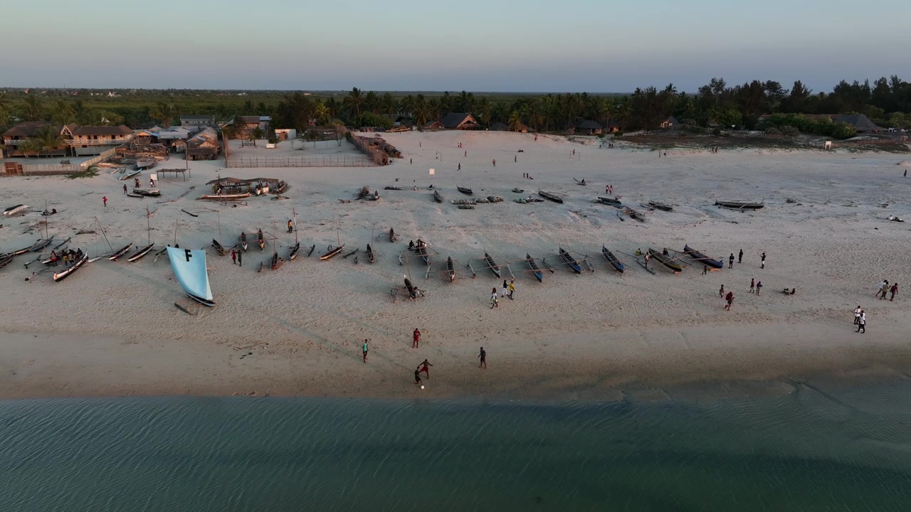 Young men play soccer on Morondava beach during sunset, Madagascar.