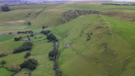 Vista-Aérea-De-La-Antigua-Carretera-Mam-Tor-Y-Montañas-Verdes-En-El-Parque-Nacional-Del-Distrito-De-Picos-En-Inglaterra,-Reino-Unido