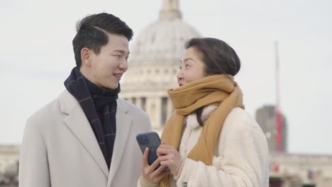 배경 1에서 세인트 폴 대성당과 밀레니엄 다리를 건너 휴일에 젊은 아시아 부부
