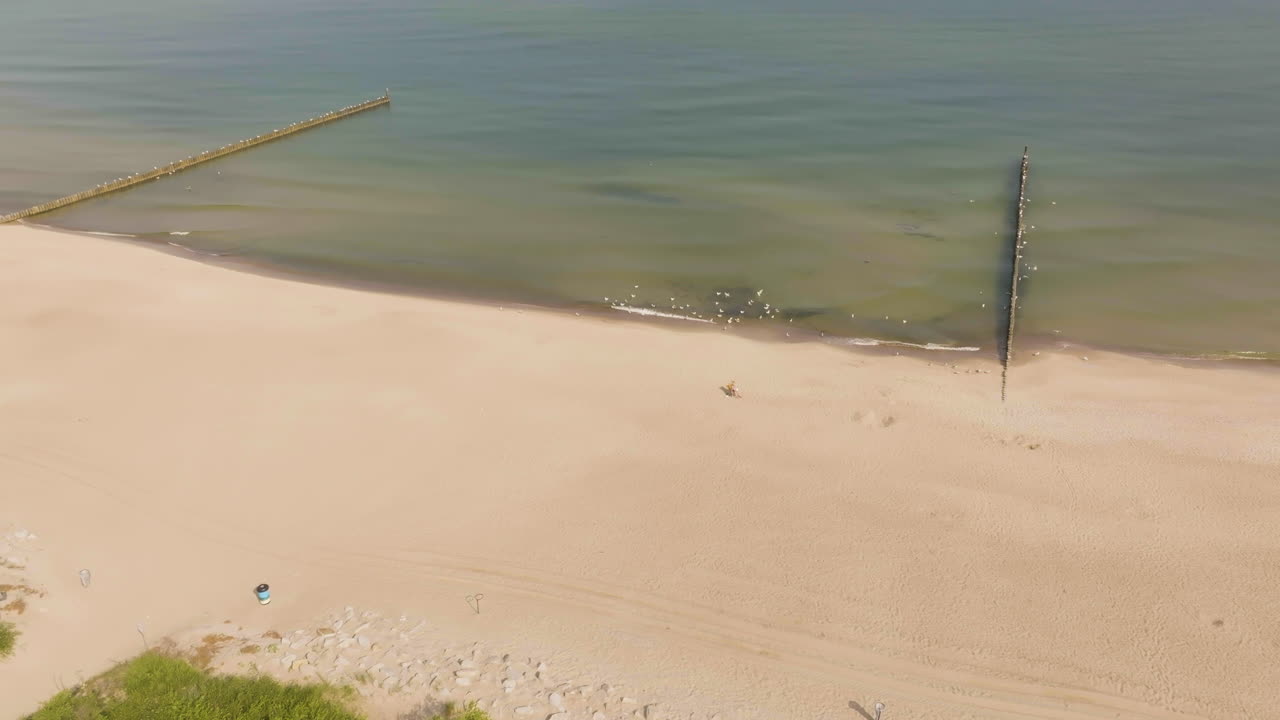 Aerial view rising in front of the Plaza Mielno beach, sunny, summer day in Poland