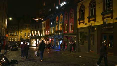 people walking along picturesque victoria street at night in edinburgh