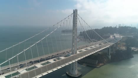 aerial shot of vehicles moving on san francisco–oakland bay bridge with city in background